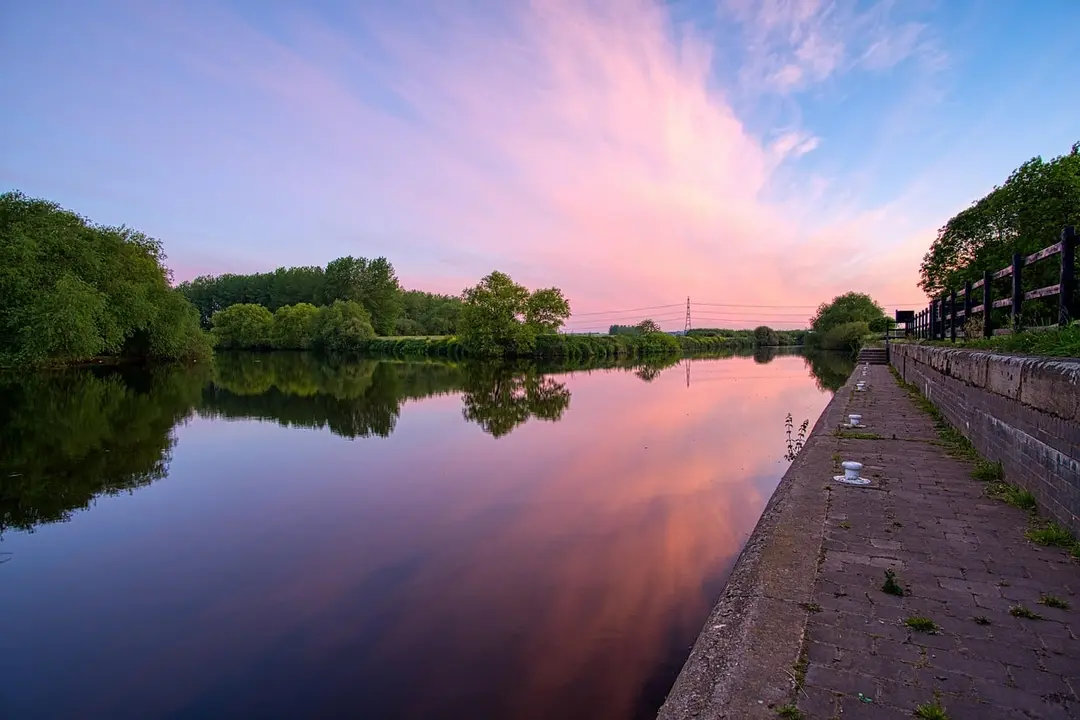 A calm river under a pink evening sky
